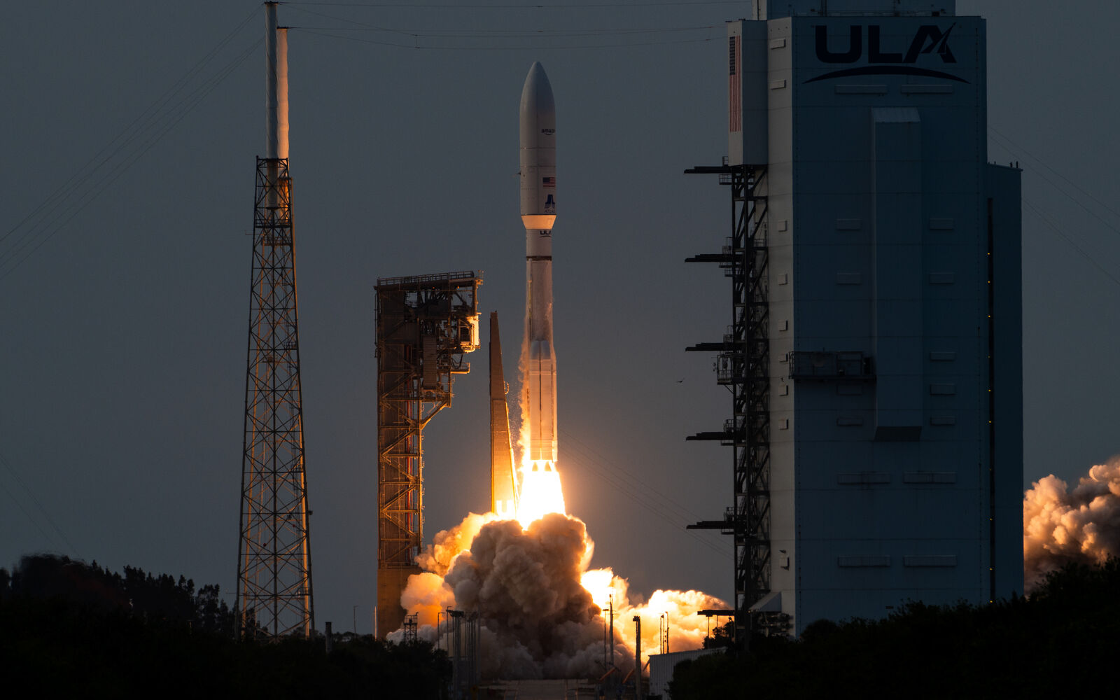 An Atlas V rocket lifting off from Space Launch Complex 41 at dusk, carrying the first production Amazon Leo satellites